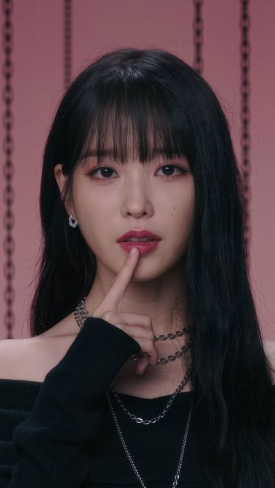 Portrait of a woman in a black sweater touching her chin