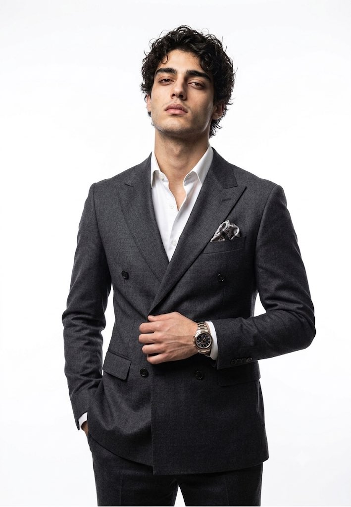 A confident executive adjusts his blazer lapel in studio light