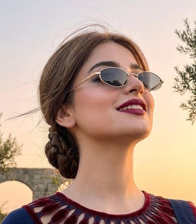 Young woman in golden sunset light looks up with confidence