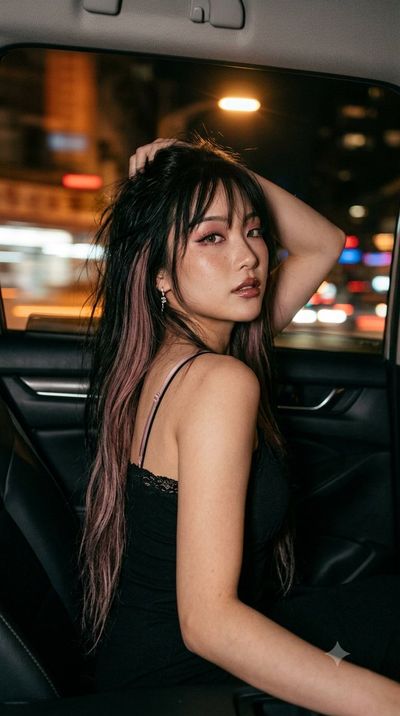 Midnight Ride: Woman Glances Back With City Lights Blurring Behind