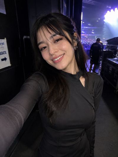 Tired singer laughs softly while walking backstage after concert