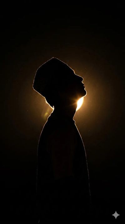 A lone man tilts his head back toward a warm glow