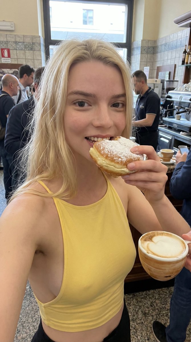 Italian girlfriend eats cream krapfen at busy train station bar