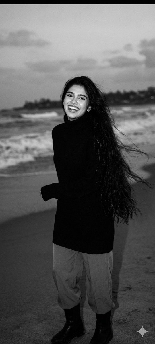 A laughing woman with long hair runs on a windy beach