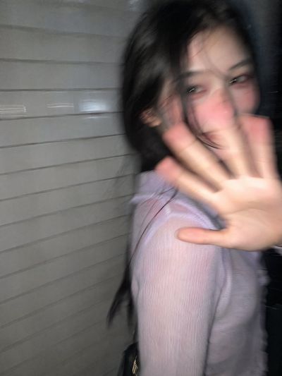 A young woman turns in surprise on a dark Tokyo street
