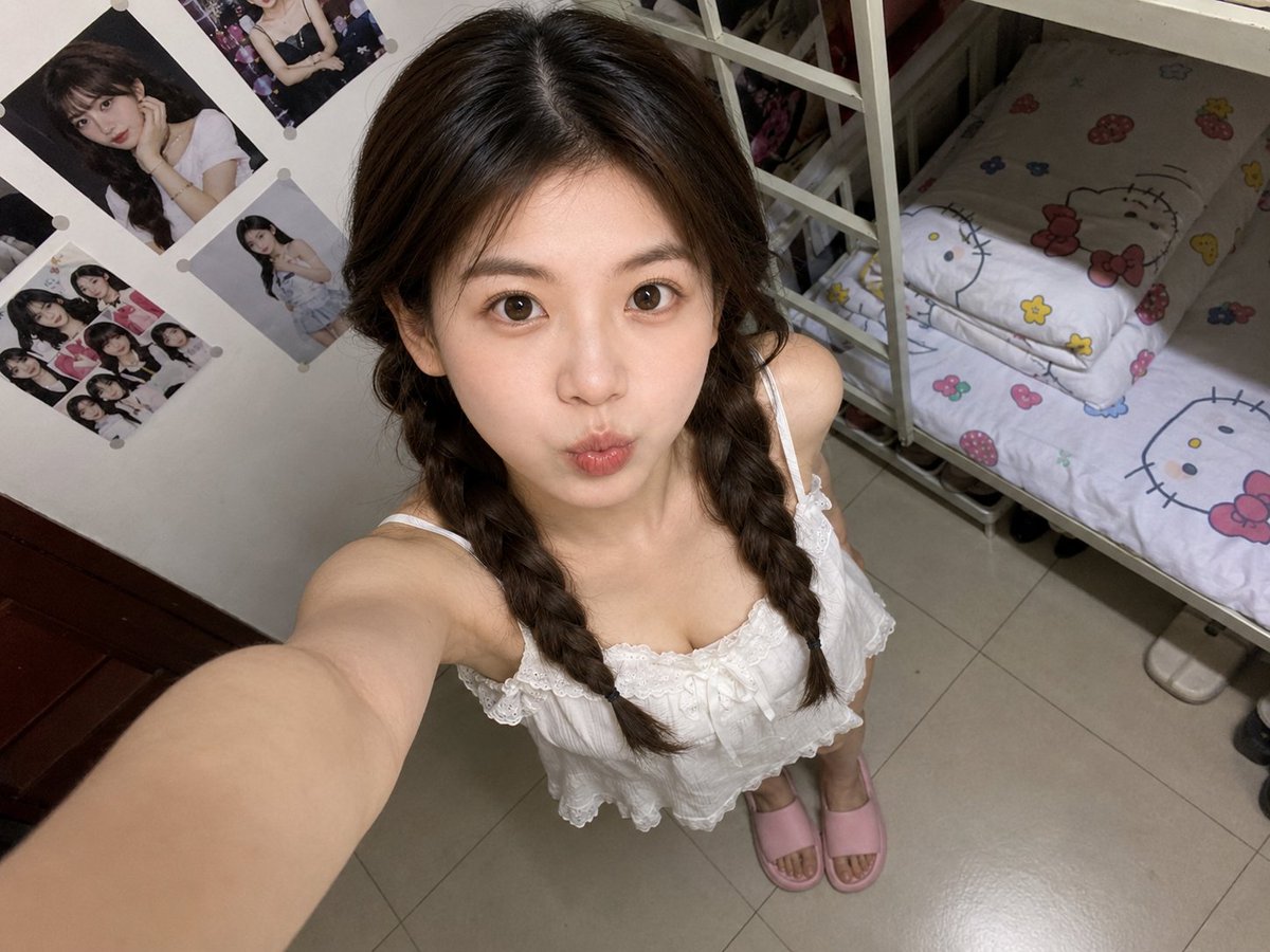 A cute student takes a high-angle selfie in her cozy dorm room
