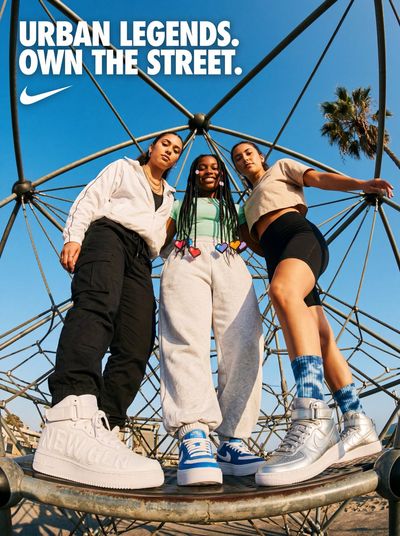 Three confident women pose on a geodesic dome under blue sky.