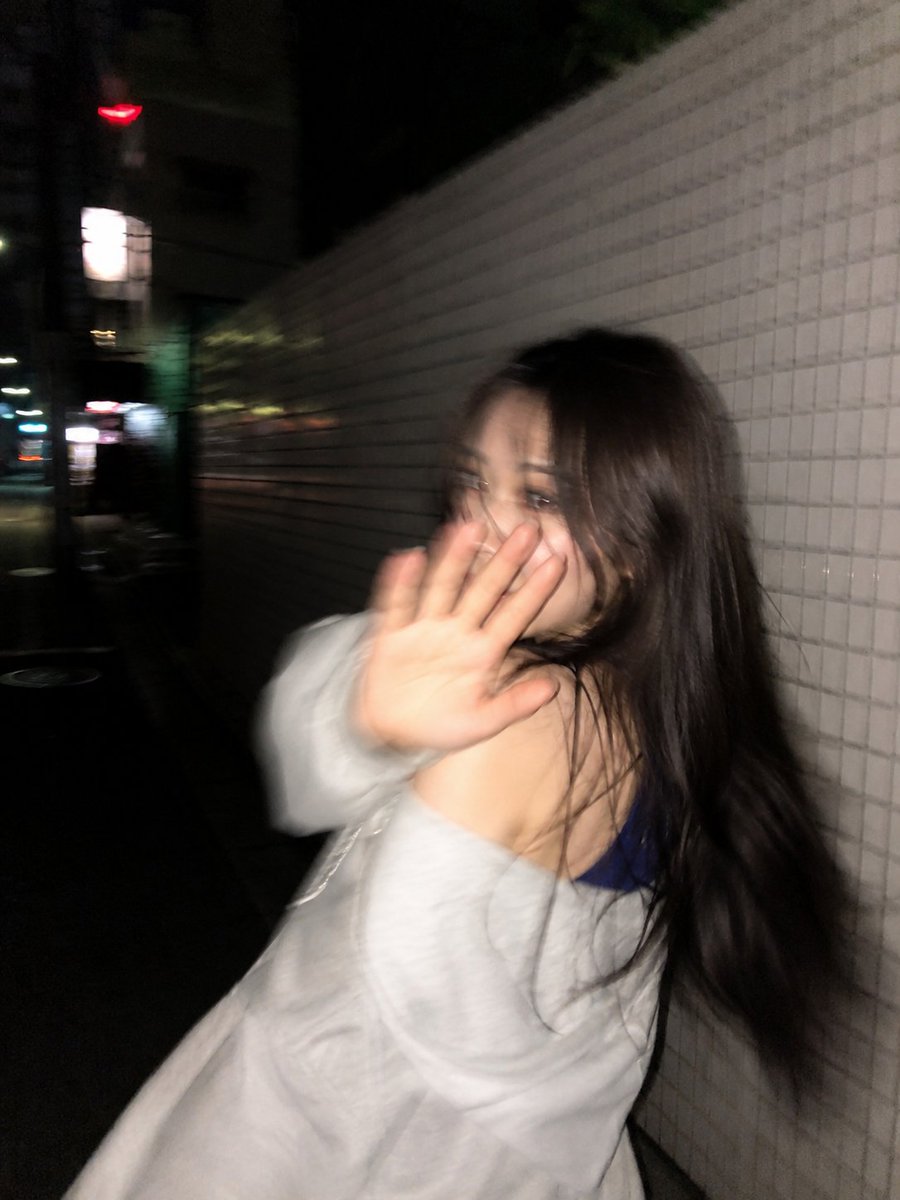 Blurred woman turns back with hand raised in Tokyo night