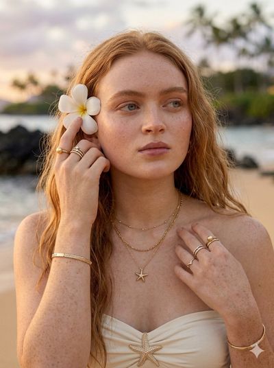 Golden sunset illuminates a blonde woman on tropical beach
