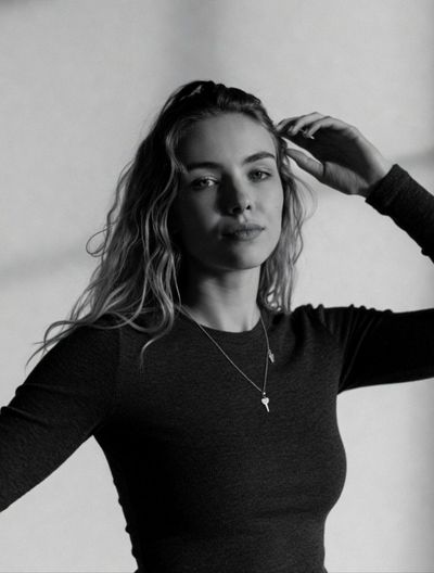 A serene young woman touches her hair in monochrome portrait