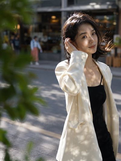 A woman in an oversized blazer catches golden afternoon light