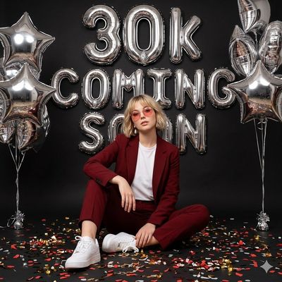 Bold Celebration: Woman in Red Suit Amid Luxe Silver Balloons