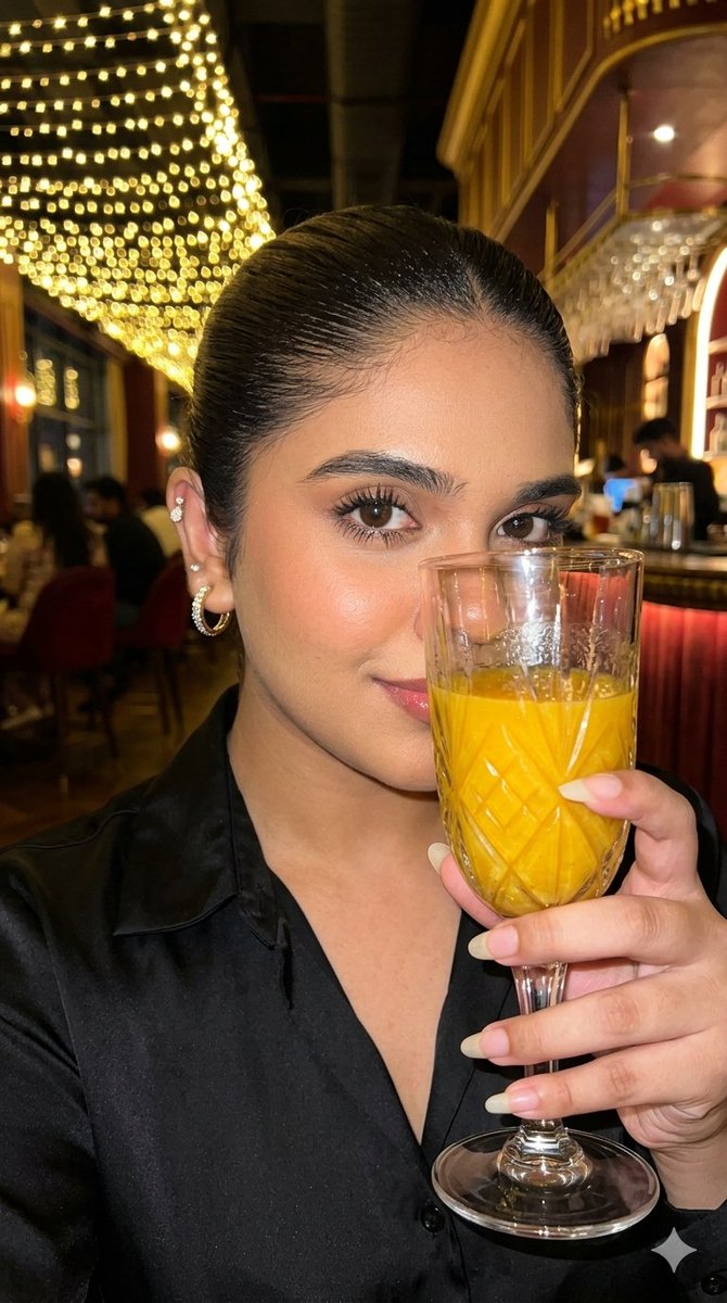 A woman holds red wine glass in a luxurious bar setting