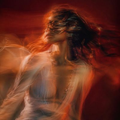 A woman's face dissolves into warm amber motion blur