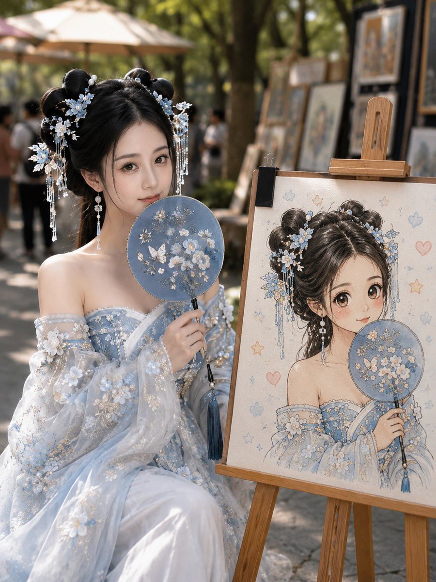 Artist sits beside easel with chibi self-portrait at market