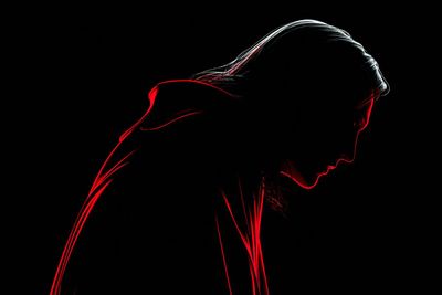A neon witch silhouette glows with bright pink and blue edges against darkness