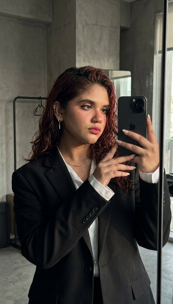 Sleek Confidence: A Mirror Selfie in a Dark Minimalist Studio