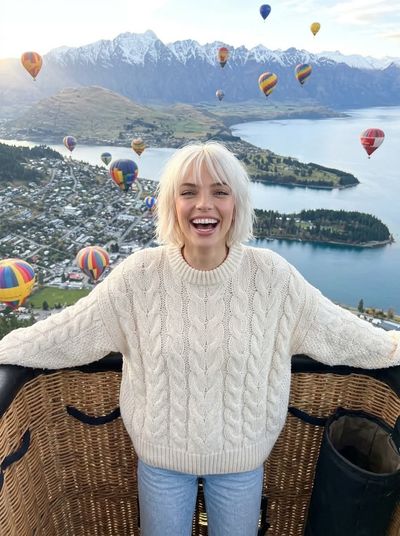 Woman laughs joyfully in hot air balloon over New Zealand mountains