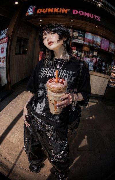 Dunkin donuts streetwear model holds coffee with donut on straw