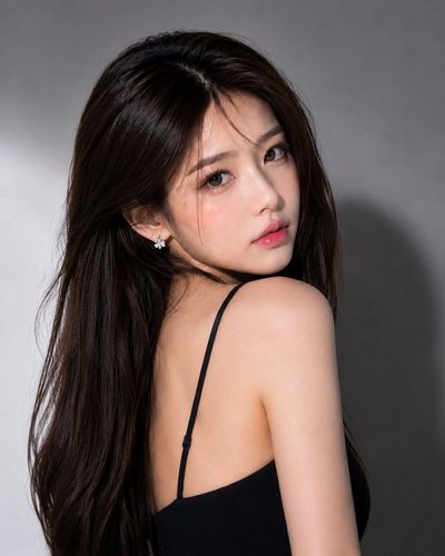 Elegant Asian woman gazes over her shoulder in soft studio light