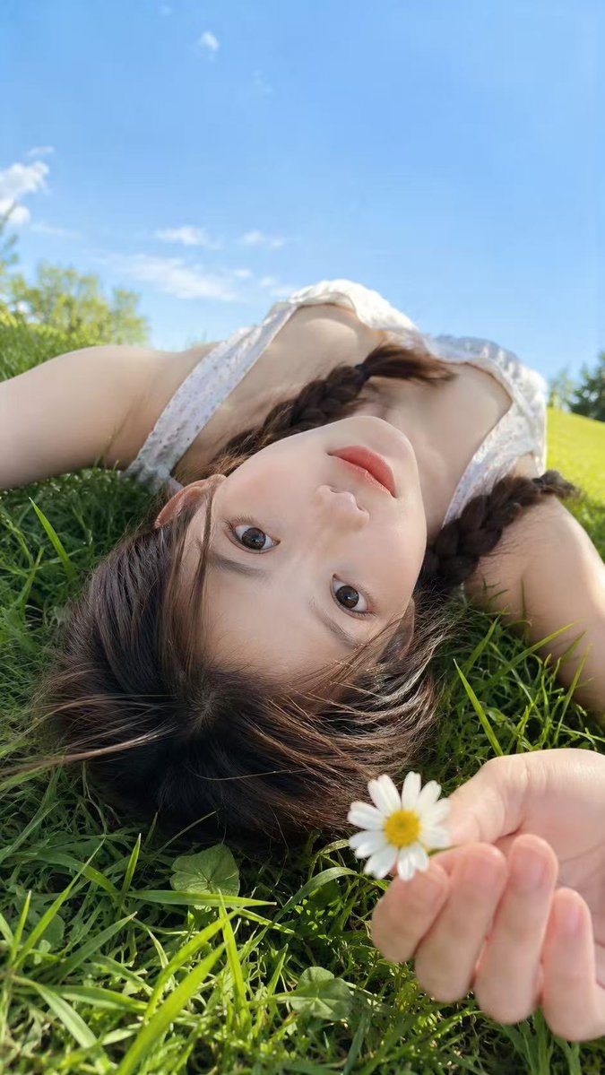 Upside-down portrait against blue sky with fresh grass