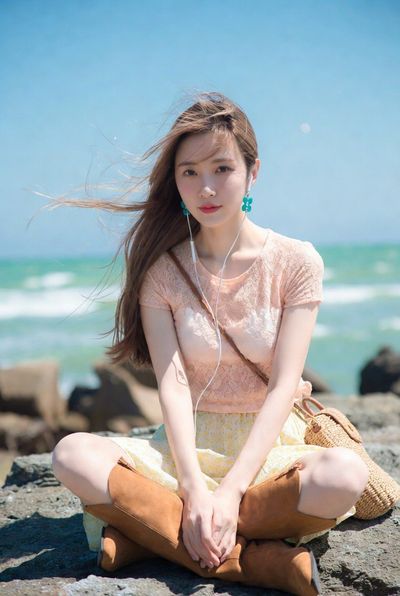 Serene Seaside Poise: Young Woman in Pastels by the Ocean