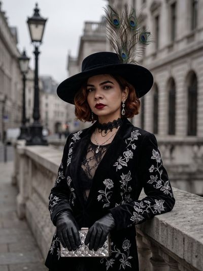 Elegant Woman in Black Velvet Leans on Stone Balustrade