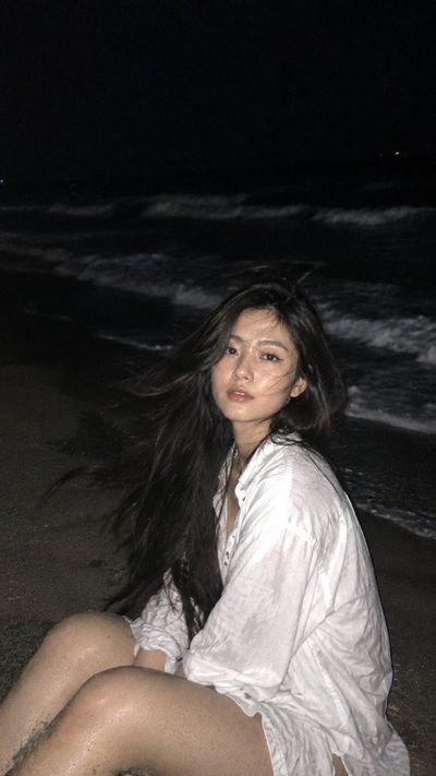 Candid Night Beach Portrait of Woman Brushing Windblown Hair