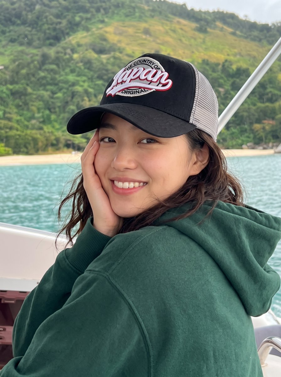 Woman in 'The Country of Japan' Hat Smiles on Tropical Boat