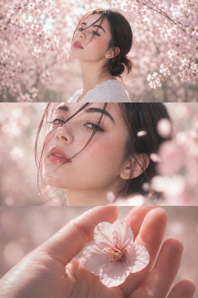 Young woman in white blouse among cherry blossoms in spring light