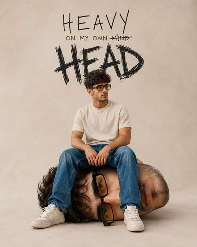 Young man sits on his own giant head in surreal portrait