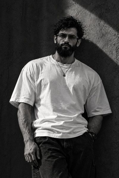 Man Leaning Against Concrete Wall in Monochrome Portrait