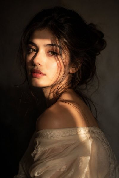 Golden light sculpts her features in a chiaroscuro portrait