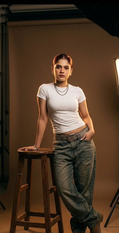 Confident woman in white tee commands moody studio portrait