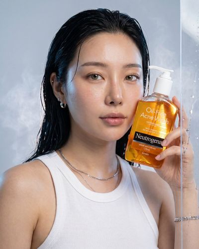 Glowing amber cleanser bottle splashes with fresh citrus and aloe vera