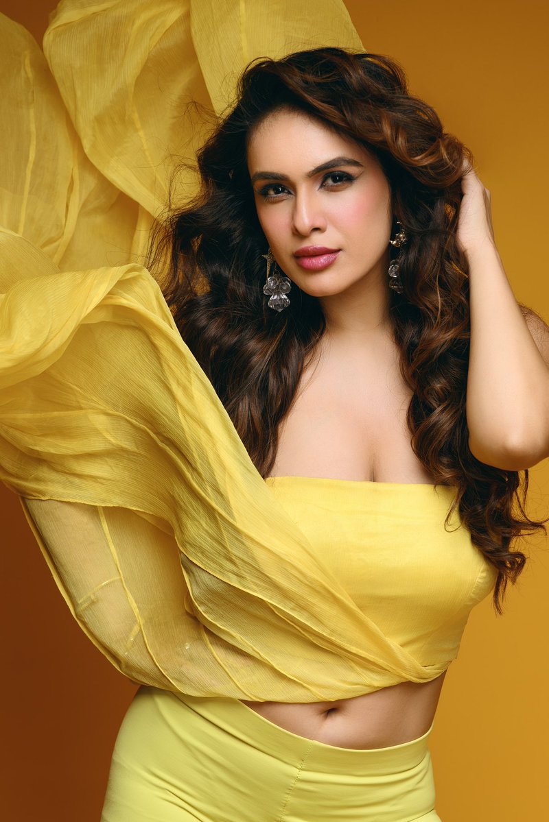 Indian model in yellow skirt and crop top poses confidently