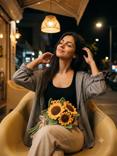 A woman sits peacefully under a warm lamp light