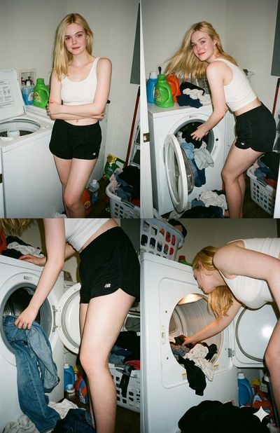 Young woman loads clothes into washer in messy laundry room