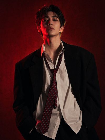 Confident East Asian model in oversized blazer under red light