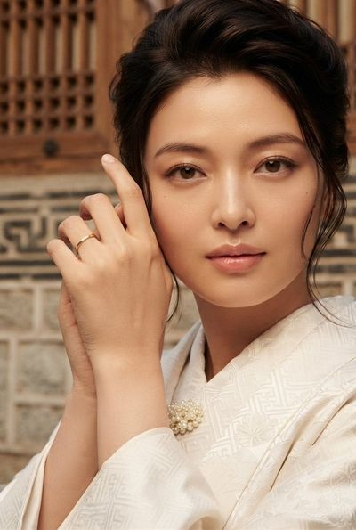 Elegant woman in traditional attire with gentle gaze and warm tones