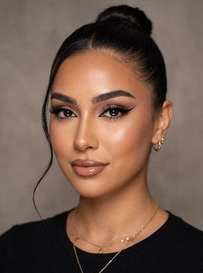 Radiant beauty portrait shows woman with sleek high bun and glowing skin