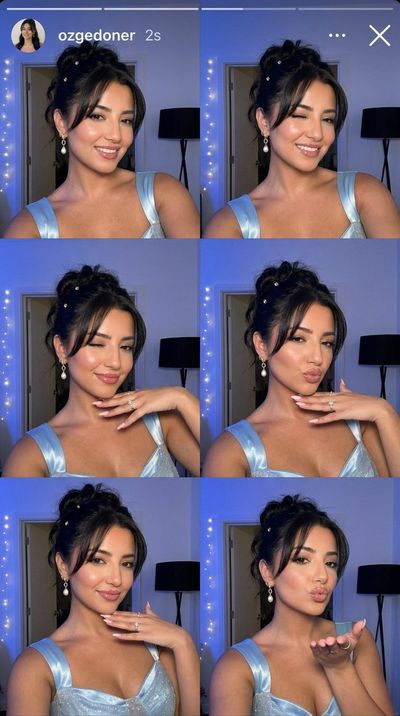 Young woman in blue glowing dress takes playful selfies at night
