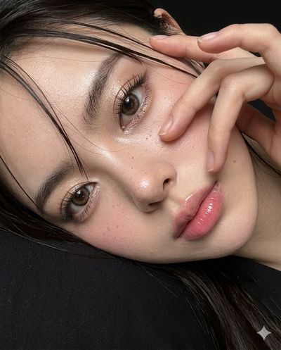 A woman lies inches from the camera with wet hair