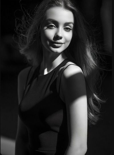 Elegant monochrome portrait captures confident gaze amid dramatic shadows