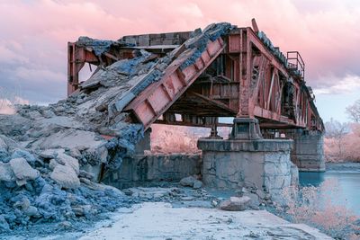 An abandoned gas station glows in infrared magenta and rust tones.