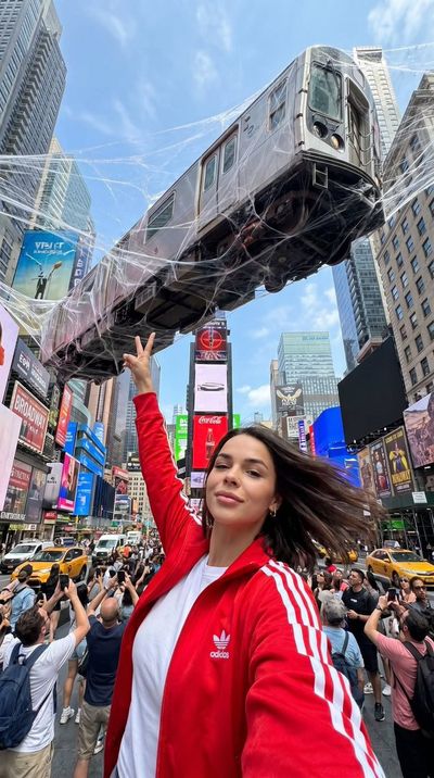 Woman captures a suspended subway train in Times Square selfie