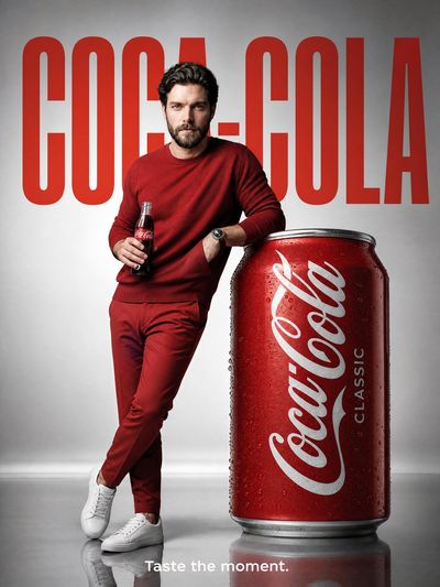 Model poses beside oversized Coca-Cola can in luxury ad