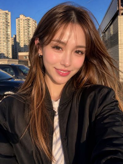 Golden hour selfie captures young woman's warm smile in city
