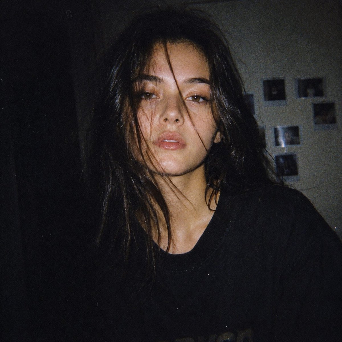 Japanese woman with pale skin stares calmly in dim flash snapshot