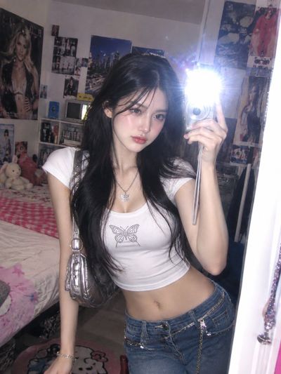 Woman snaps candid mirror selfie with silver digital camera in Y2K bedroom